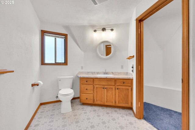 bathroom featuring toilet, baseboards, and vanity