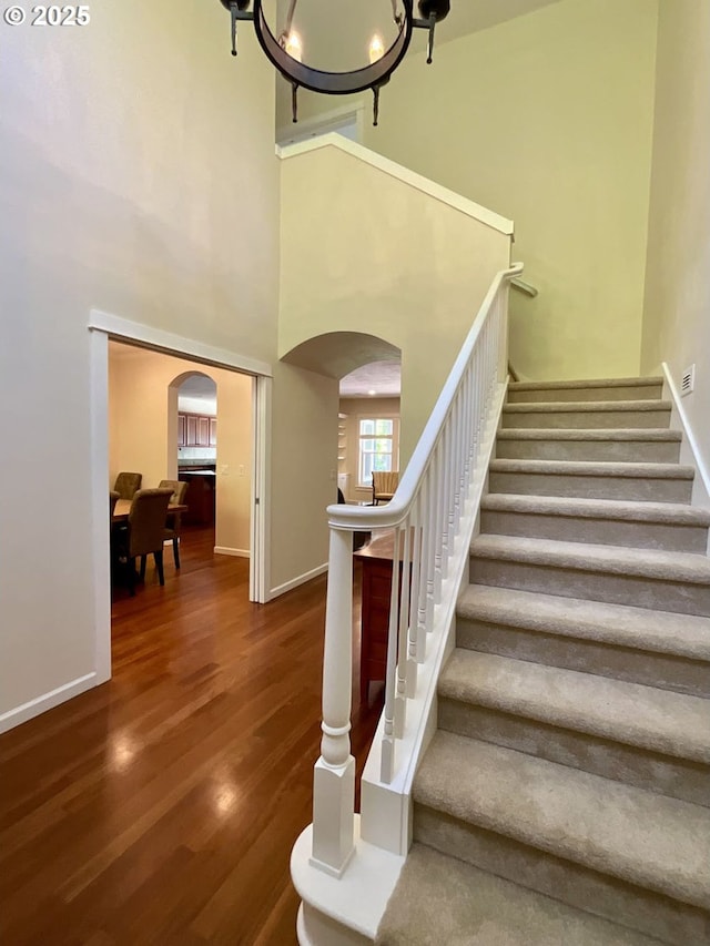 419 Salty Way, Eugene, OR 97404 - staircase featuring arched walkways, wood finished floors, baseboards, and a high ceiling