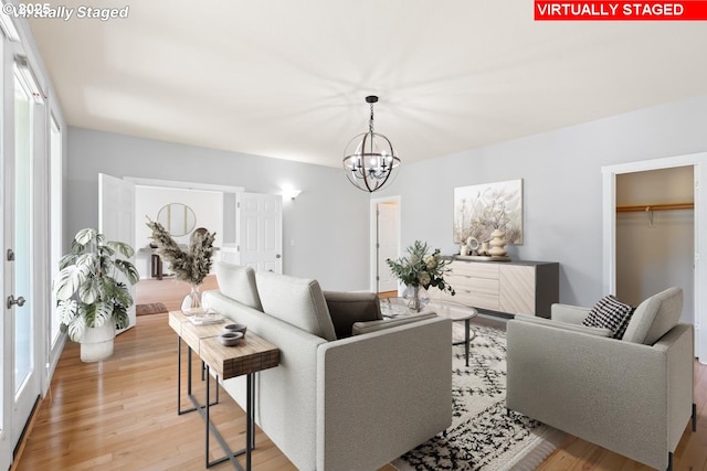 living room with an inviting chandelier and light wood-style floors
