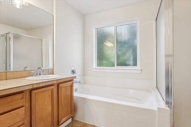 bathroom with vanity, a garden tub, and a stall shower