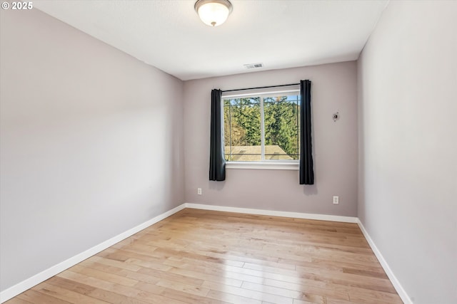 empty room with baseboards, visible vents, and light wood-style flooring