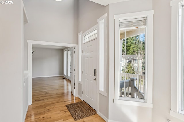 entrance foyer with baseboards and light wood finished floors