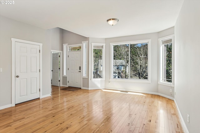 interior space with baseboards, visible vents, and light wood-type flooring