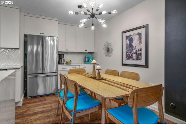 2393 SW Park Pl Unit 113, Portland, OR 97205 - dining space with wood finished floors and a chandelier