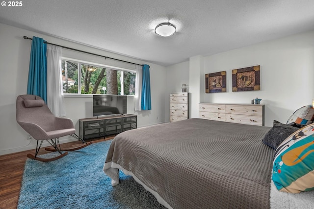 2393 SW Park Pl Unit 113, Portland, OR 97205 - bedroom with wood finished floors, a textured ceiling, and baseboards