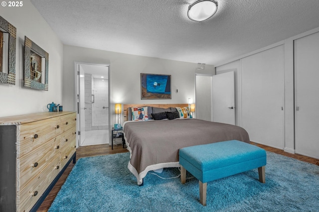 2393 SW Park Pl Unit 113, Portland, OR 97205 - bedroom featuring a textured ceiling, wood finished floors, and ensuite bath