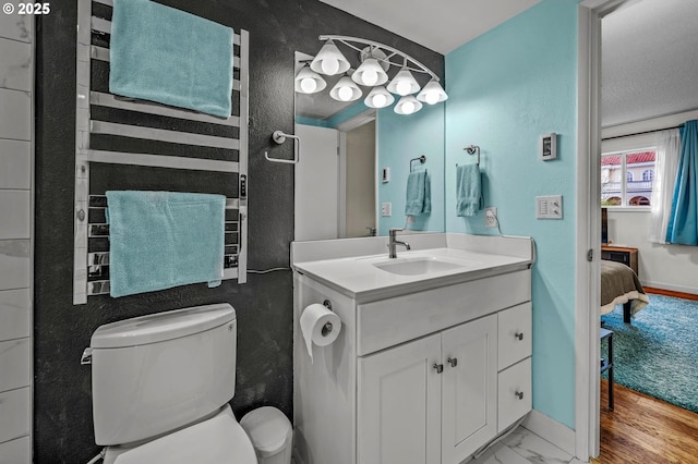 2393 SW Park Pl Unit 113, Portland, OR 97205 - ensuite bathroom with vanity, toilet, baseboards, and marble finish flooring