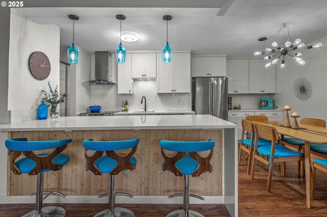 2393 SW Park Pl Unit 113, Portland, OR 97205 - kitchen with freestanding refrigerator, wall chimney exhaust hood, tasteful backsplash, dark wood-style floors, and a sink