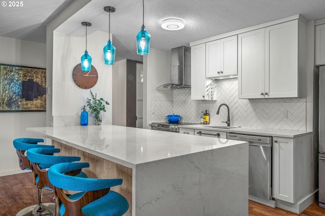 2393 SW Park Pl Unit 113, Portland, OR 97205 - kitchen featuring stainless steel dishwasher, wall chimney range hood, a sink, decorative backsplash, and light stone counters