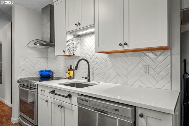 2393 SW Park Pl Unit 113, Portland, OR 97205 - kitchen featuring appliances with stainless steel finishes, wall chimney exhaust hood, a sink, backsplash, and white cabinets