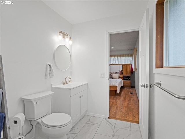 bathroom featuring toilet, marble finish floor, ensuite bath, and vanity