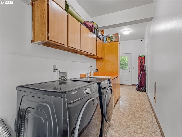 laundry area featuring cabinet space, washer and clothes dryer, and baseboards