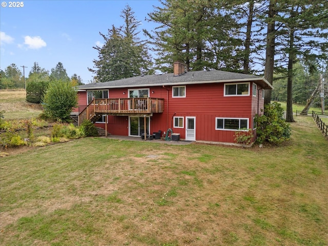 rear view of house featuring a yard, a wooden deck, a patio, and a chimney