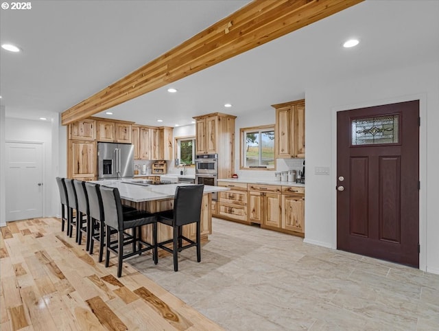 kitchen featuring light countertops, appliances with stainless steel finishes, a kitchen breakfast bar, and recessed lighting