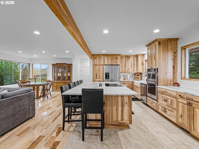 kitchen with recessed lighting, light stone counters, and appliances with stainless steel finishes