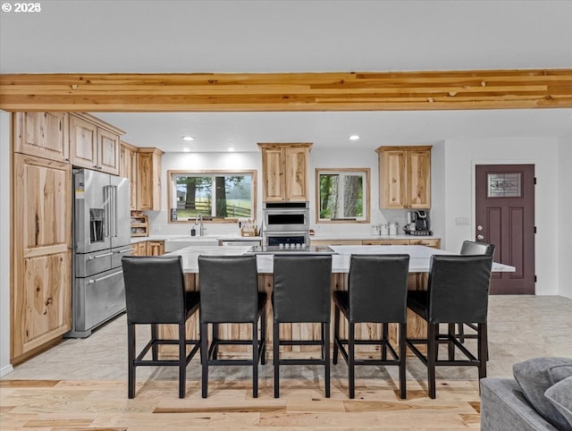kitchen featuring stainless steel appliances, light brown cabinets, and light countertops