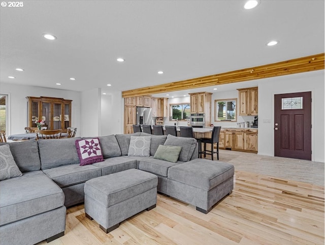 living area with light wood finished floors and recessed lighting