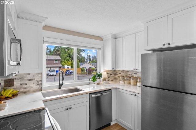 6696 Doral Dr SE, Salem, OR 97306 - kitchen featuring stainless steel appliances, a sink, white cabinetry, decorative backsplash, and a textured ceiling