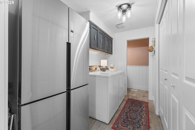 6696 Doral Dr SE, Salem, OR 97306 - laundry room featuring washing machine and clothes dryer, light wood-style floors, and cabinet space