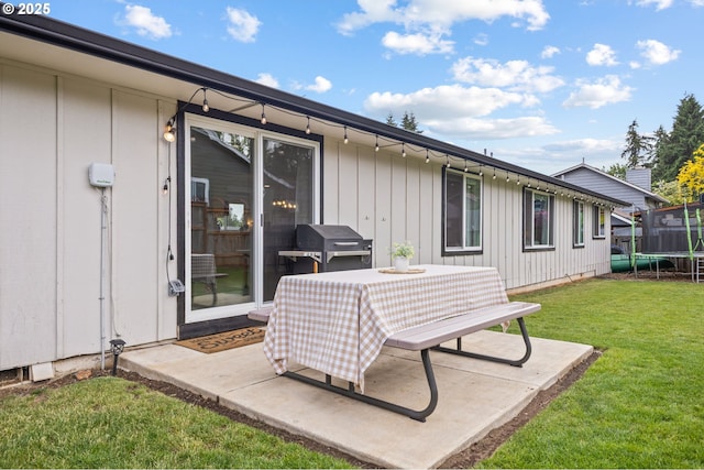 6696 Doral Dr SE, Salem, OR 97306 - back of house featuring a trampoline, board and batten siding, a lawn, and a patio