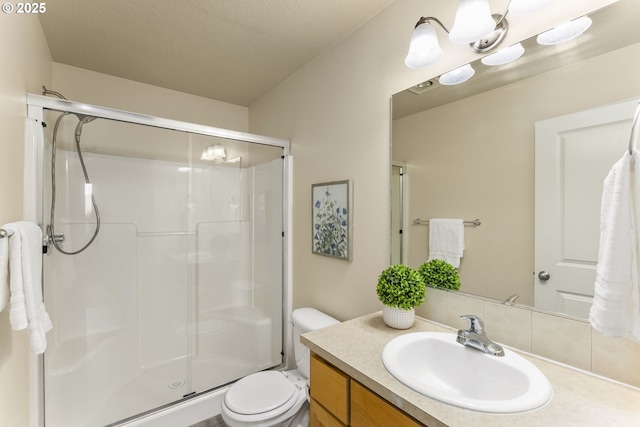 bathroom with vanity, toilet, and a stall shower