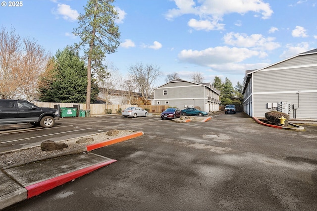 uncovered parking lot featuring fence