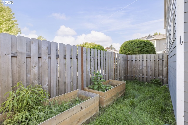 view of yard with a vegetable garden and fence private yard