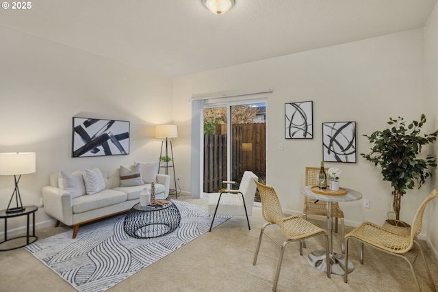 living area featuring carpet flooring and baseboards