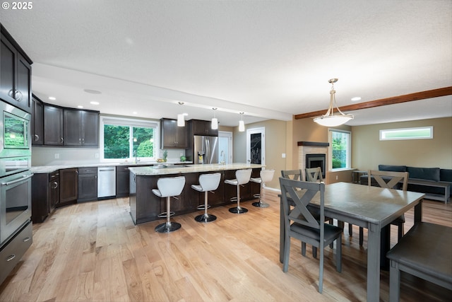 1412 SW Chastain Ave, Gresham, OR 97080 - dining room with healthy amount of natural light, light wood finished floors, a fireplace, and recessed lighting