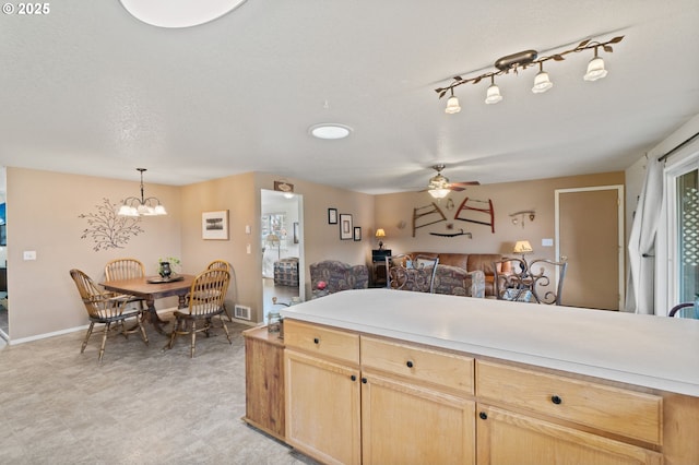 kitchen featuring hanging light fixtures, ceiling fan with notable chandelier, a textured ceiling, and light brown cabinets