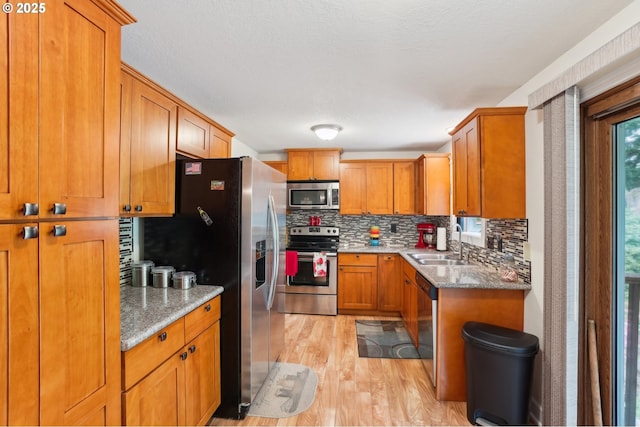 2202 NE 203rd Ave, Fairview, OR 97024 - kitchen featuring stainless steel appliances, a sink, light wood-style flooring, and brown cabinetry