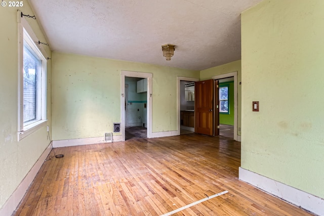 6861 N Sky St, Portland, OR 97203 - spare room with a textured ceiling, wood-type flooring, and baseboards