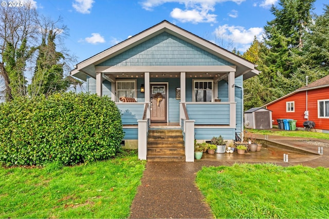 bungalow featuring covered porch and a shed