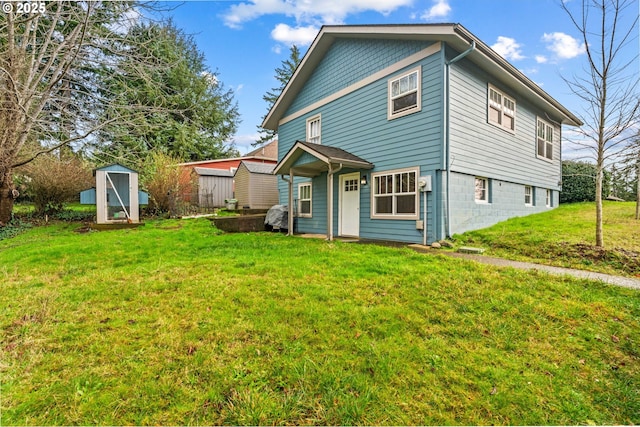 rear view of property with a lawn and a storage unit