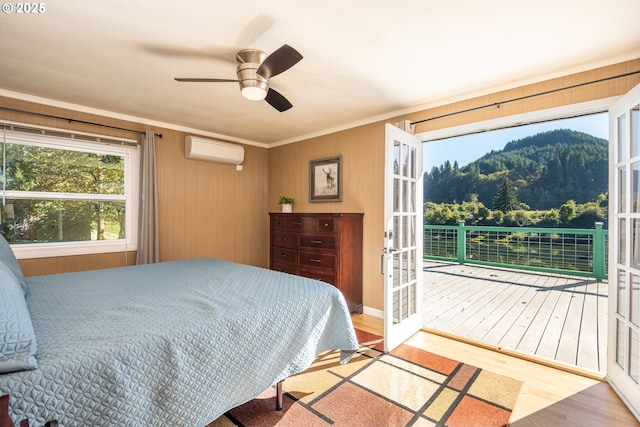 bedroom featuring crown molding, hardwood / wood-style floors, access to exterior, a wall mounted air conditioner, and french doors