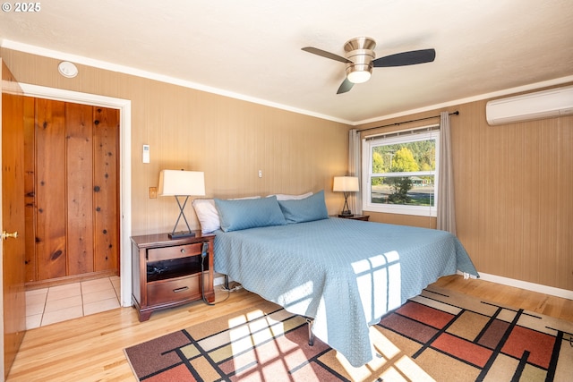 bedroom featuring a wall mounted air conditioner, crown molding, wood-type flooring, and ceiling fan