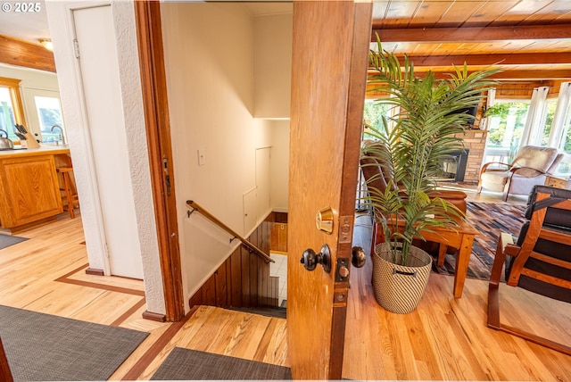 staircase with beamed ceiling and wood-type flooring