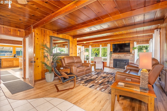 living room with wooden walls, wooden ceiling, light hardwood / wood-style floors, and beamed ceiling