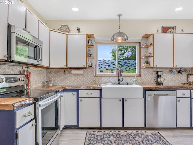 91196 Youngs River Rd, Astoria, OR 97103 - kitchen featuring appliances with stainless steel finishes, open shelves, light wood finished floors, backsplash, and recessed lighting