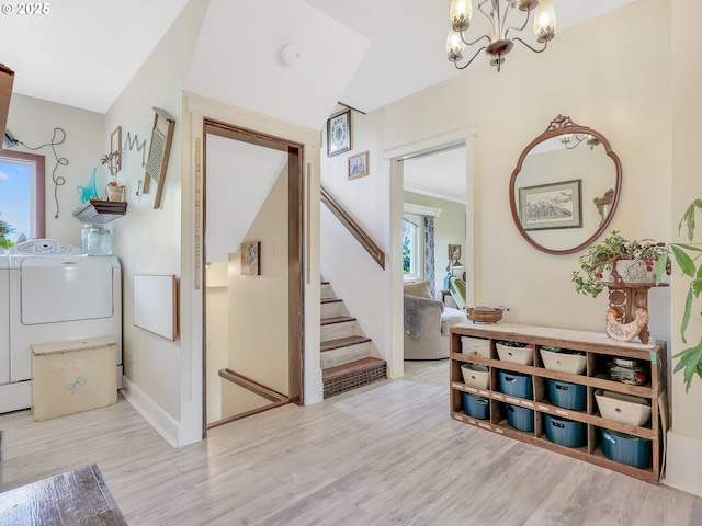 91196 Youngs River Rd, Astoria, OR 97103 - entryway with washing machine and clothes dryer, a chandelier, stairway, and wood finished floors