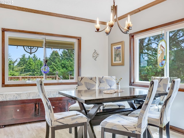 91196 Youngs River Rd, Astoria, OR 97103 - dining area featuring healthy amount of natural light, a chandelier, crown molding, and light wood-style flooring