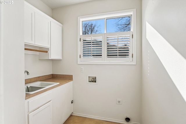 washroom with cabinet space, washer hookup, and a sink
