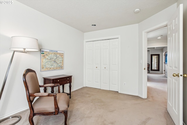 living area with baseboards and light colored carpet