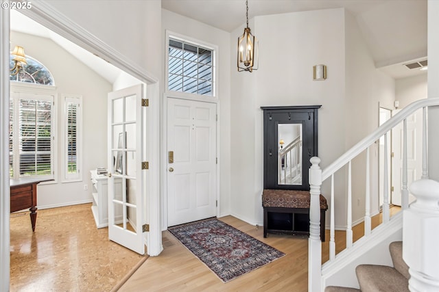 entrance foyer with a wealth of natural light, stairway, visible vents, and wood finished floors