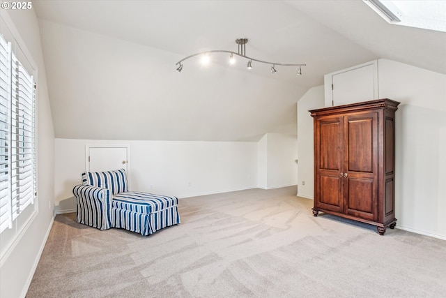 sitting room featuring a healthy amount of sunlight, baseboards, vaulted ceiling, and light colored carpet