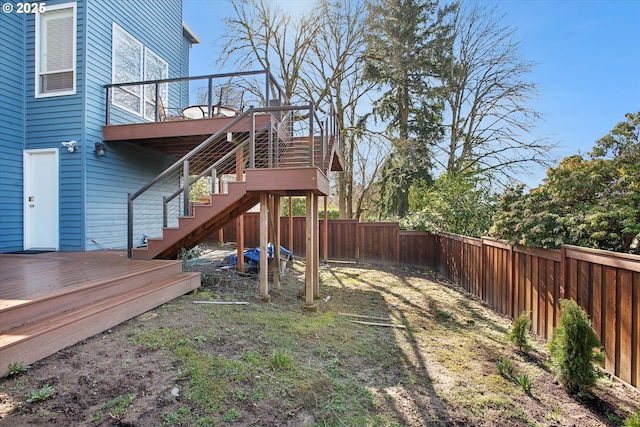 view of yard with a fenced backyard, stairway, and a deck