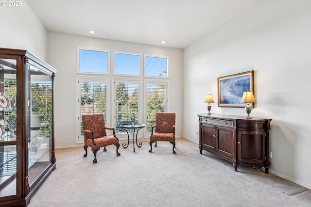 living area featuring recessed lighting, light carpet, and baseboards