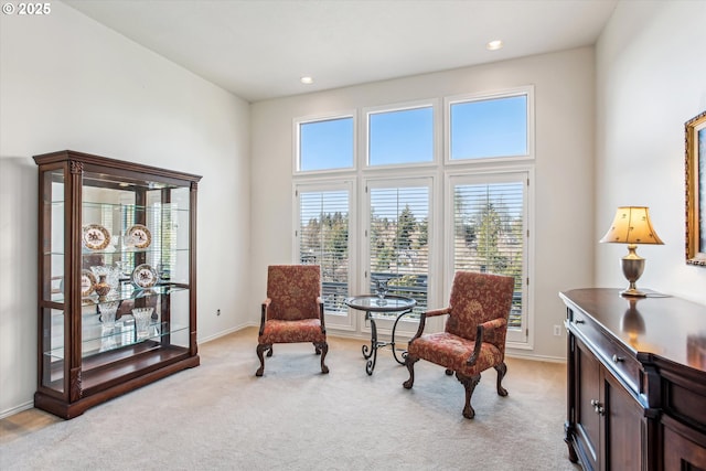 living area featuring light carpet, recessed lighting, and baseboards