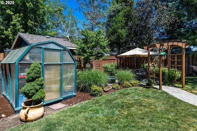 view of greenhouse with fence, a playground, and a yard