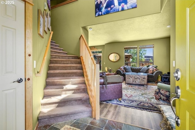 staircase with a textured ceiling